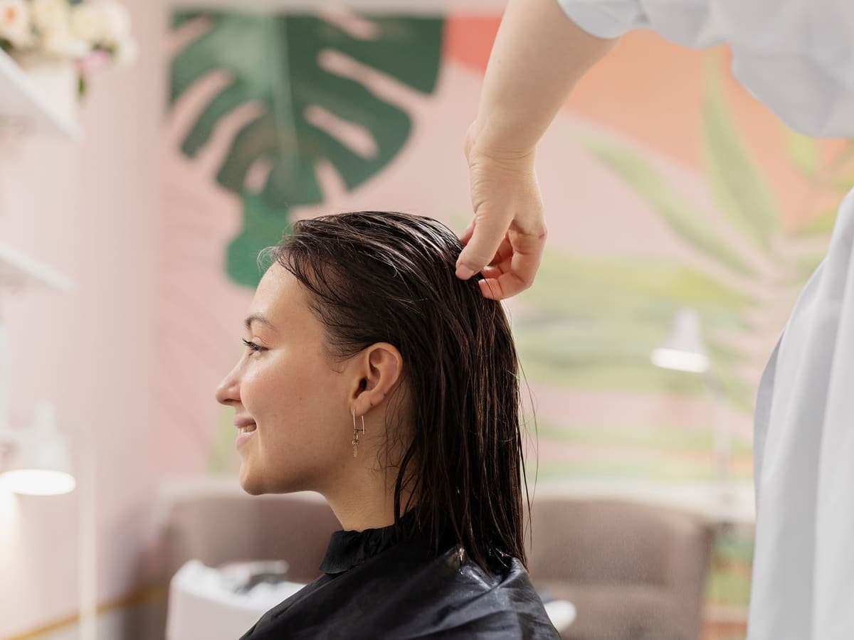 Client receiving a hair treatment in a bright salon